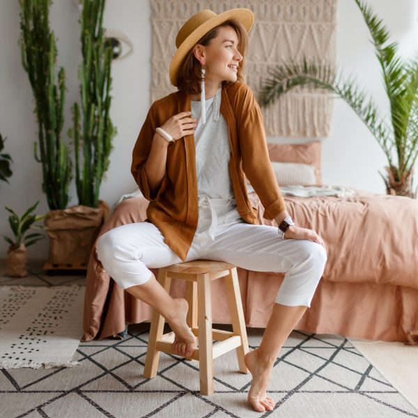 happy-woman-in-straw-hat-posing-over-bohemian-interior-background-.jpg