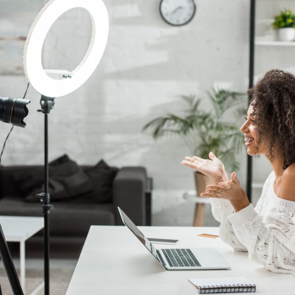 side-view-of-happy-african-american-influencer-in-braces-gesturing-near-digital-camera.jpg